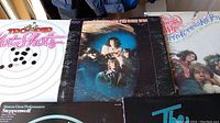 Five classic rock vinyl albums with cover art laid out on a surface showing Trooper Hot Shots, The Guess Who American Woman, The Band Big Pink, Steppenwolf and The Who albums.