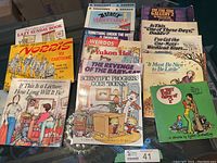 Photo of humour books piled showing various titles including Calvin & Hobbes Lazy Sunday Book, Norris cartoons, and other humour collections.