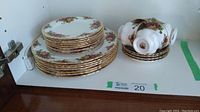 Stacks of dinner and side plates alongside teacups and saucers