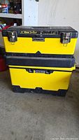Front view of stacked yellow and black Stanley tool boxes showing metal latches and 23-inch metal toolbox label on top box.