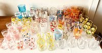 Overview of 62 painted drinking glasses and one painted mug in various patterns