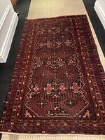 Full view of the wool rug laid on the floor showing overall pattern and shape.