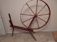 Side angle showing the entire wool winder with large wheel and supporting wooden frame.