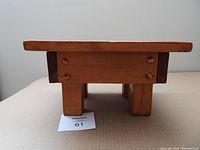 Side view of the wooden child's step stool showing solid legs and construction.