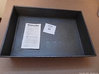 Top down view of large rectangular KitchenAid non-stick bakepan with instruction paper inside