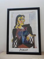 Framed print showing full artwork of Picasso's Portrait of Dora Maar with visible black frame on white wall.
