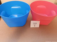 Top view showing blue and red large Tupperware bowls side by side on a countertop, highlighting size and color.