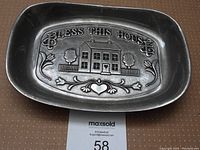 Top view showing entire stainless steel tray with embossed "Bless This House" and house motif design.
