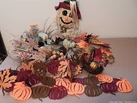 Leaf and pumpkin garlands with berries and small decorative pumpkins on a table