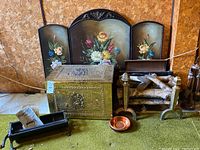 Full view of fireplace accessories set including fire screen, brass chest, log holder with logs, copper bowl, and andirons.