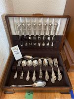 Full view of wooden case opened showing arrangement of flatware set