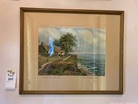 Framed wall art showing the cottage by the sea scene, mounted and signed by the artist.