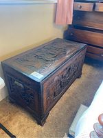 Three-quarter view of chest showing overall shape, carved panels and bracket feet.