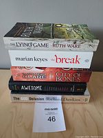 Stack of five books showing titles and authors on spines and edges.