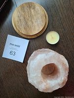 Salt rock tealight holder, wooden base, and single tealight candle displayed separately on wood surface.