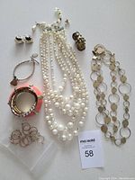 Overview of all jewelry items laid flat including pearl necklaces, bracelets, rings, and earrings.