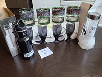 Top view showing all items: 4 Coca Cola glasses, boxed gray goblets, water bottle box, infuser bottle box