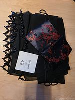 View of the purse with floral pattern laid on the scarf showing the black beaded fringe.