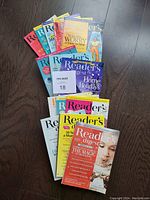 Top view of the magazines fanned out, showing multiple colorful covers and titles including Reader's Digest topics on worry and home holidays.