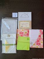 Stationery sets with floral patterns, green envelopes, and gold accent stationery, some sealed in plastic.