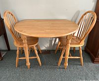 3 piece pine dining set including oval table and two spindle back chairs.