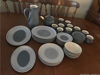 Overview of Denby Blue Echo pottery set including plates, bowls, cups, teapot, and jug on wooden table.