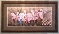 Close-up image of the framed print showing detail of pink orchids and wooden frame.