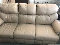 Front view of the beige leather 3-seater sofa showing the overall condition and plush cushioning on backrest and armrests.