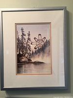 Framed sun print showing a natural landscape with trees, mist and water with stylized Indigenous sun figure in the sky.