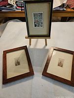 Three framed antique miniatures displayed, two laying flat and one upright on a stand to show overall lot.