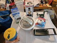Overview of eight kitchen gadgets including an apple peeler, citrus juicer, rotary chopper, spiralizer, and Starfrit box.
