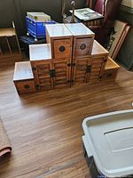 Front view of the paired step chests showing drawers and cabinet doors