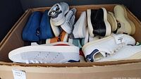 Box containing multiple pairs of sneakers in various colors