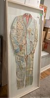 Framed full-view of collage artwork showing map suit design.