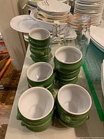 Overview of stacked soup bowls alongside glass bottle and canister