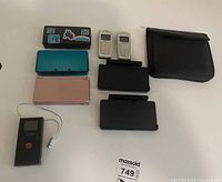 Overview of all items on white background: consoles, docks, phones, DVD-ROM case, camera