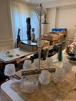 Full view on table showing chandelier with eight clear studded glass shades and twisted central column