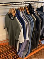 Rack view showing front four T-shirts and adjacent sweaters