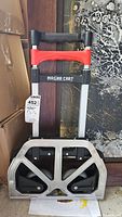 Foldable Magna Cart dolly fully folded showing handle and base with wheels