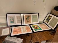 Overview of six black plastic frames on two tables showing various framed menus