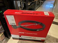 Sealed red cardboard box with Kamado Joe Joetisserie branding