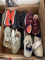 Overhead view of box containing ten pairs of various Reebok shoes