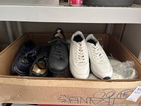 Both pairs of sneakers in cardboard box