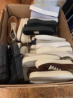 Overview of 13 pairs of sneakers in a cardboard box showing various colors and styles