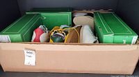 Open cardboard shipping box containing multiple Valsport sneaker boxes and loose shoes