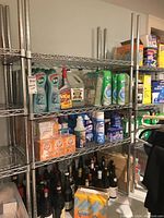 Front view of assembled Uline wire shelving unit holding cleaning supplies and bottles for scale