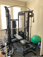 Full view of weight machine, bench and mat with window background