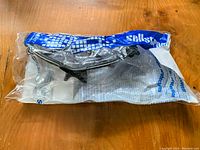 New eye protector glasses sealed in clear plastic packaging placed on a wooden surface