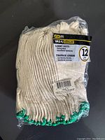 Pack of 12 light duty gloves in original plastic packaging, showing label and gloves inside.
