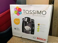 Photo of the boxed Bosch Tassimo T47 single cup coffee maker showing brand, model, and packaging details.